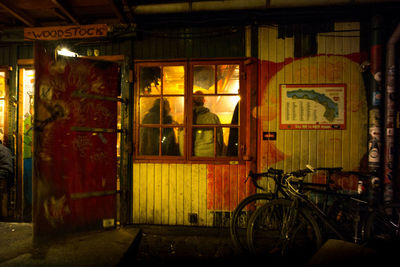 Bicycle by illuminated building in city at night