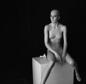 Mannequin with box against black background