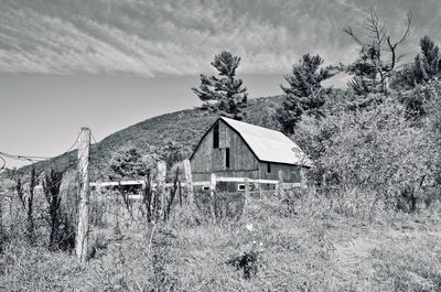 Abandoned house on field against sky