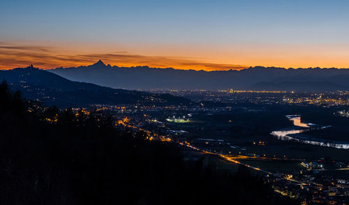 High angle shot of illuminated cityscape against sky during sunset