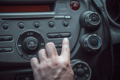 Cropped hand of man playing music in car