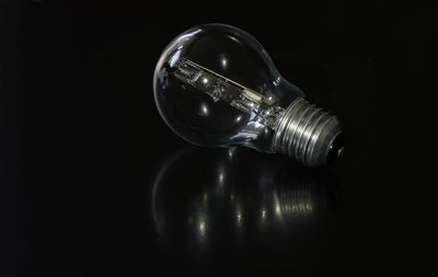 Close-up of light bulb over black background