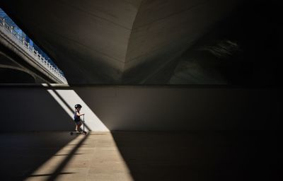 Man walking on bridge in city