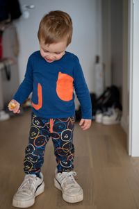 Portrait of boy playing with toy on floor at home