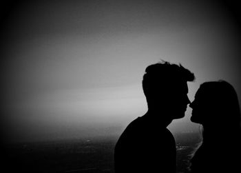 Silhouette couple standing against clear sky during sunset