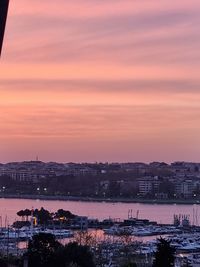 High angle view of river by buildings against sky at sunset