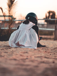 Rear view of woman on street during sunset