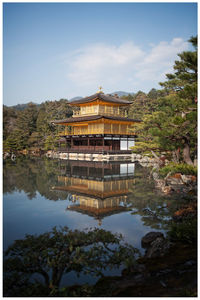 Built structure by lake against sky