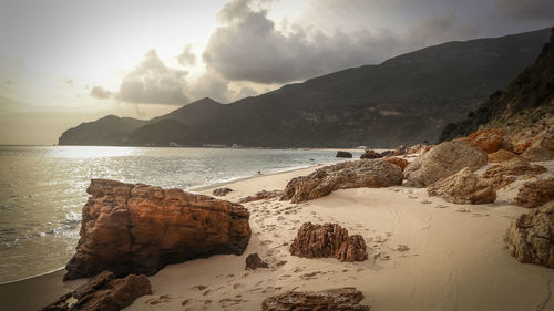 Scenic view of sea and mountains against sky