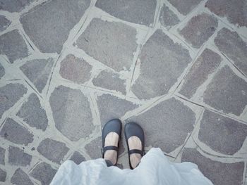 Low section of woman standing on footpath