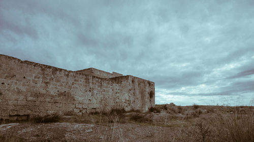 Old building on field against sky