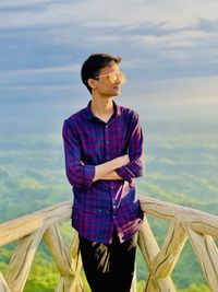 Full length of teenage girl standing in sea against sky