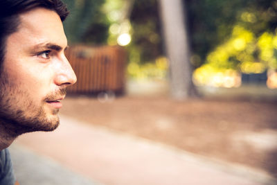 Portrait of young man looking away outdoors