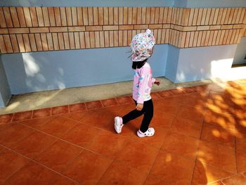 Full length of girl standing on tiled floor