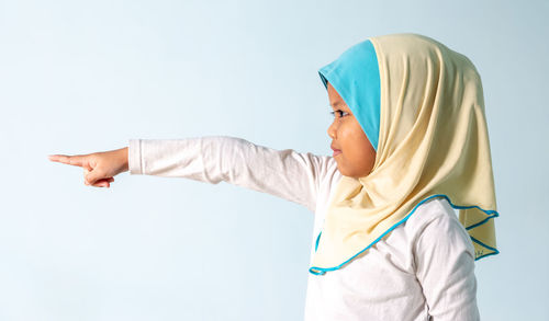 Side view of baby girl against white background