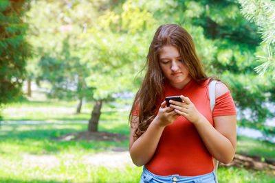 Teenage girl using mobile phone outdoors