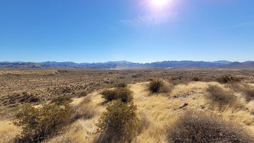 Scenic view of arid landscape against clear blue sky