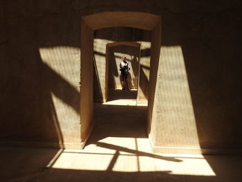 Girl standing in corridor during sunny day