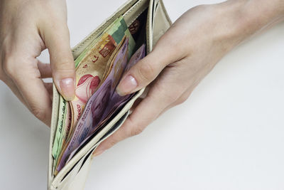 Close-up of woman holding hands over white background