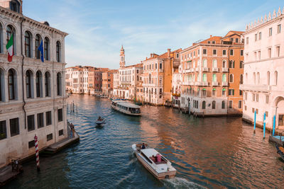 Boats moored in canal in city