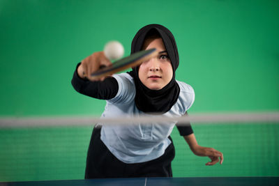 Portrait of young woman sitting on tennis