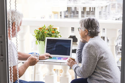 Man using mobile phone while sitting on table