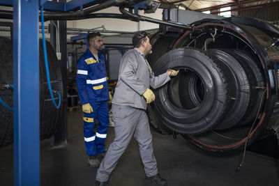 Two tire repairmen working in factory