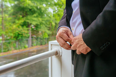 Close-up of man fastening trousers