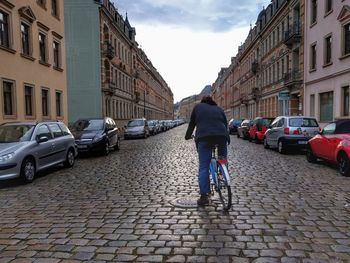 Rear view of people walking in front of street