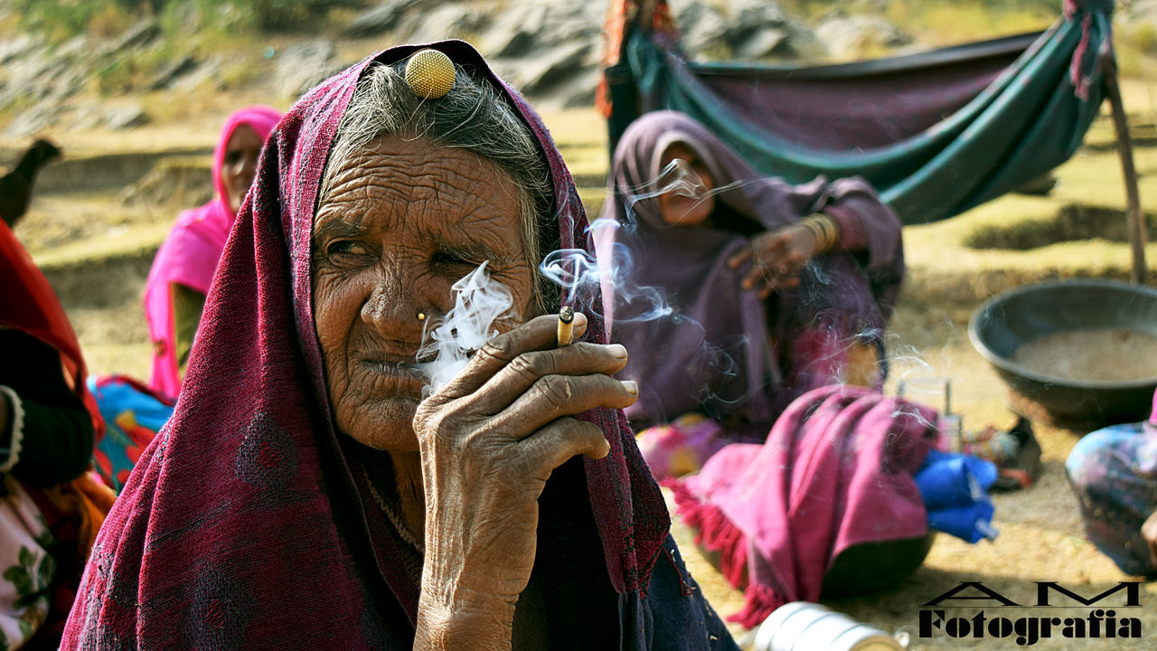 CLOSE-UP OF YOUNG WOMAN IN BACKGROUND