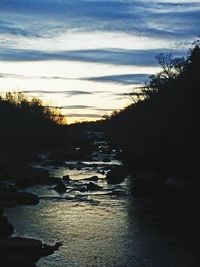 Scenic view of river against sky at sunset