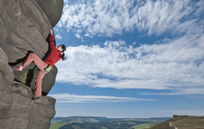 Woman bouldering at windgather rocks in the british peak district