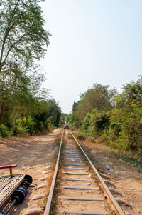 Railroad track amidst trees against clear sky