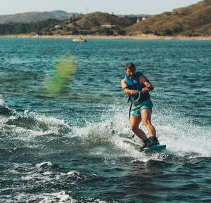 Full length of man wakeboarding in sea