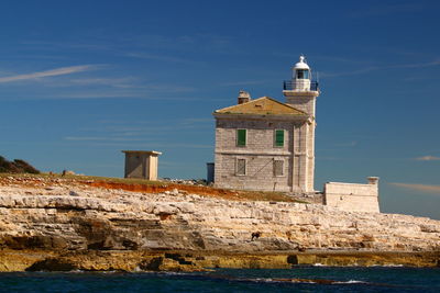 Lighthouse and goats against the sky