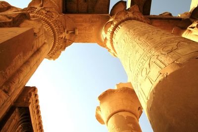 Hieroglyphics on columns against clear sky