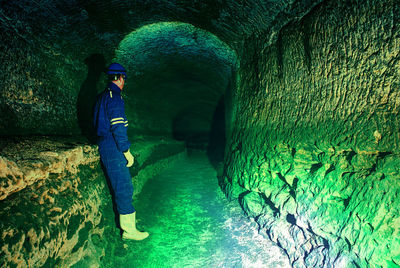 Side view of man standing in tunnel