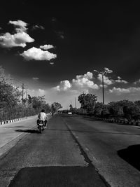 Cars on road against sky in city