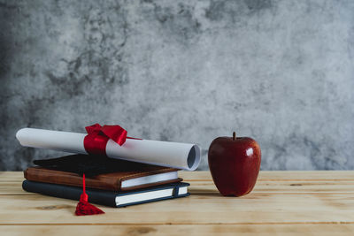 Close-up of red apple on table against wall