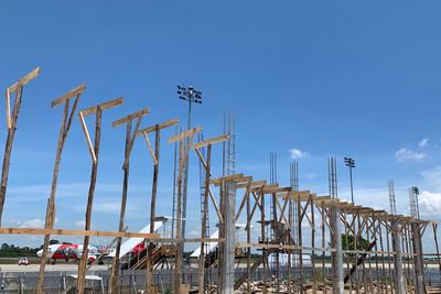 Low angle view of cranes against blue sky