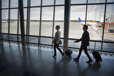 Business people walking with luggage at airport