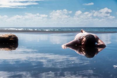 Man in sea against sky