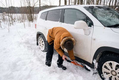 Low section of man skiing on snow covered road