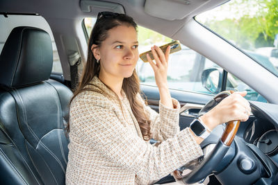 Portrait of young woman sitting in car