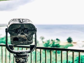 Close-up of metal railing against sea