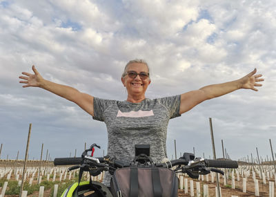 Portrait of smiling woman standing against sky