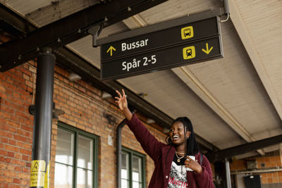 Young woman waving at train station