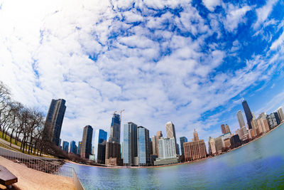 Panoramic view of swimming pool by buildings against sky