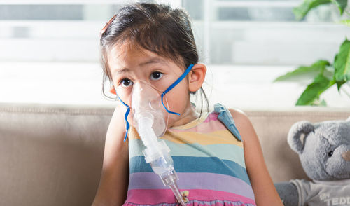 Side view of young woman with iv drip at home