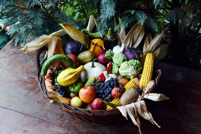 High angle view of fruits and vegetables in wicker basket on wooden table